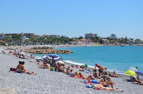a group of people laying on a beach at Appartement à 50 mètres de la plage in Cagnes-sur-Mer