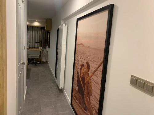 a hallway with a painting of a woman on the wall at Deluxe Apartment at the seaside in Pasaport Alsancak Izmir in Konak