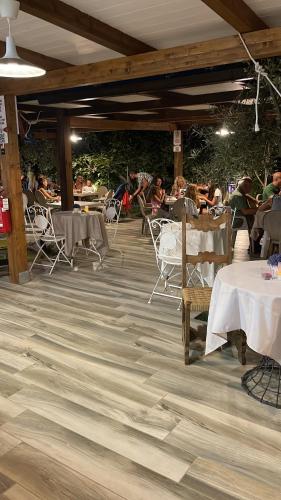 een restaurant met tafels en stoelen en mensen zittend bij Appartamenti Pousada Michelino in Parghelia