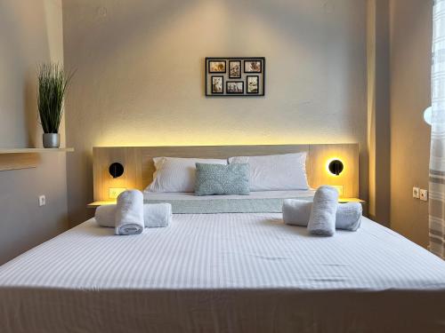a bedroom with a large white bed with two pillows at MyseA VillasNikiti in Nikiti