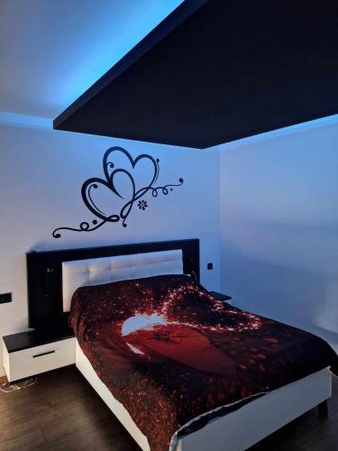 a bedroom with a bed with a heart on the wall at Villa la passerelle in Payrin-Augmontel