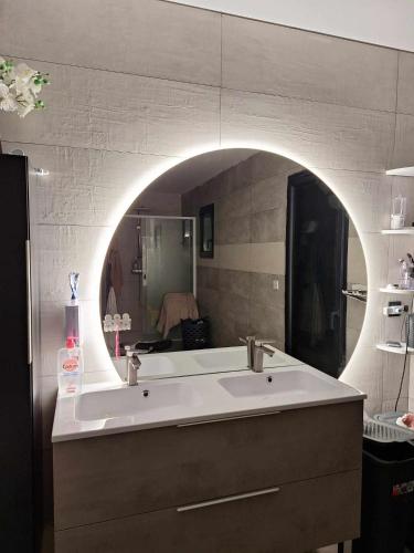 Villa la passerelle في Payrin-Augmontel: حمام مع حوض أبيض كبير ومرآة