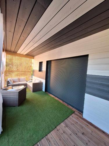 una sala de estar con 2 sofás y una alfombra verde en Villa la passerelle, en Payrin-Augmontel