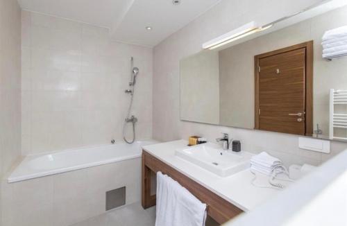 亞霍里納的住宿－Apartment B327 Aparthotel Vucko，一间带水槽、浴缸和镜子的浴室