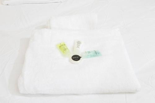 een witte handdoek met een tandenborstel en een fles erop bij Spacious and Luxurious 5 Bedroom Town House for 9 in Kent