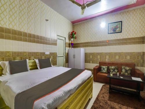 1 dormitorio con 1 cama grande y nevera en Collection O Hotel Paradise And Restaurant, en Kāshīpur