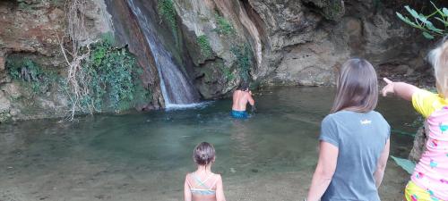 a group of people standing in the water near a waterfall at Filoxenia Sea View in Parga