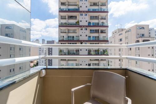 a chair on a balcony with a tall building at LFlats no Hotel Stella Vega (EX-Mercury Ibirapuera) in Sao Paulo