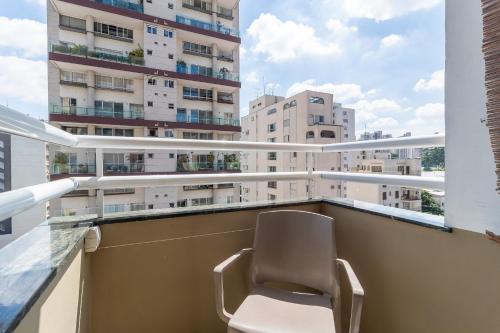 a chair on a balcony with a view of a building at LFlats no Hotel Stella Vega (EX-Mercury Ibirapuera) in Sao Paulo