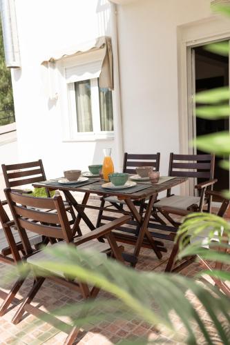 a wooden table and chairs on a patio at MyseA VillasNikiti in Nikiti