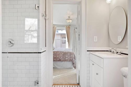 a white bathroom with a sink and a mirror at Luxury 6600 sq.ft Stunning Home/Sleeps 10+ in Minneapolis