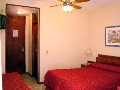 a bedroom with two beds and a ceiling fan at Hotel Chiavari in San Bernardo