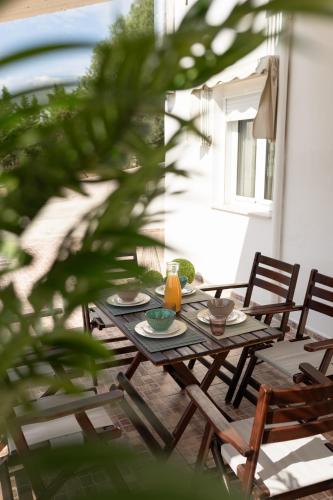 a wooden table with plates and bowls on a patio at MyseA VillasNikiti in Nikiti