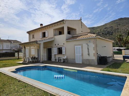 a villa with a swimming pool in front of a house at Villa Nelly in Alcudia