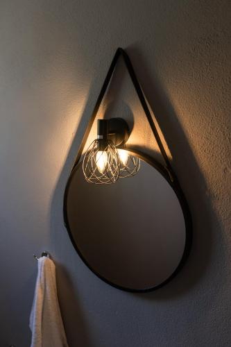 a black mirror hanging on a wall with a towel at MyseA VillasNikiti in Nikiti