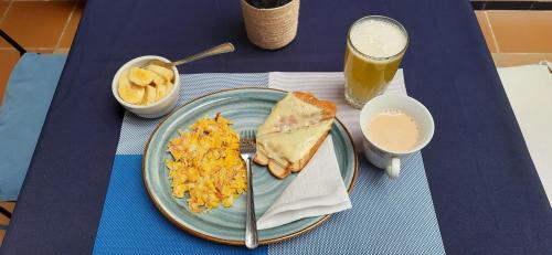 a blue table with a plate of breakfast food and a drink at Villa del Prado in Medellín