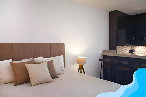 a bedroom with a large bed with white pillows at Minimalist Studio with Pool and FREE Scooter in Cozumel