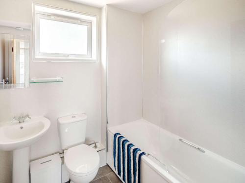 a white bathroom with a toilet and a sink at 3 Bed in Thame 88963 in Shabbington