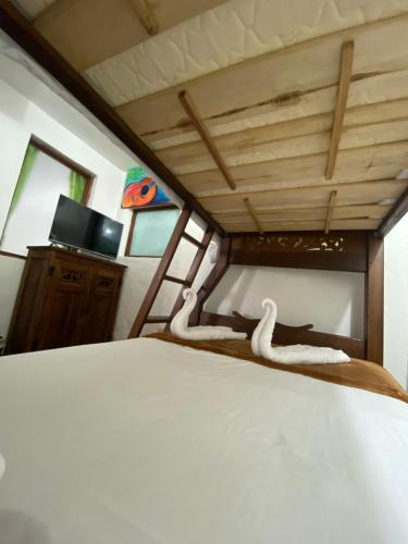 a bedroom with a bed and a tv in a room at Hospedaje casa Chisakui- Acogedora Casa en Villa de Leyva in Villa de Leyva