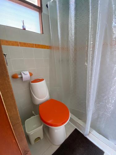 a bathroom with a red toilet and a shower at Hospedaje casa Chisakui- Acogedora Casa en Villa de Leyva in Villa de Leyva