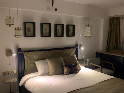 a bedroom with a bed with four pictures on the wall at Deluxe Apartment at the seaside in Pasaport Alsancak Izmir in Konak