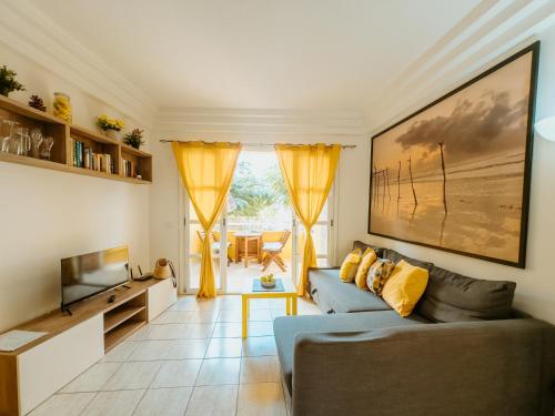 a living room with a couch and a television at Sunshine by the ocean 1BR apartment COSTA ADEJE by Aqua Vista Tenerife in Adeje