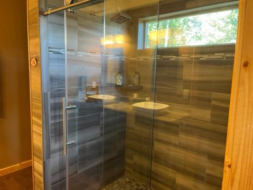 uma cabina de duche em vidro na casa de banho com um lavatório em RidgeWalk Main House em Angel Fire