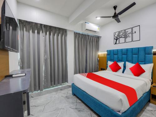 a bedroom with a large bed with red pillows at OYO 82103 Hotel Galaxy in Surat