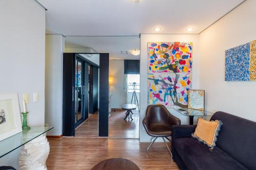 a living room with a couch and a painting on the wall at LFlats no Hotel Stella Vega (EX-Mercury Ibirapuera) in Sao Paulo