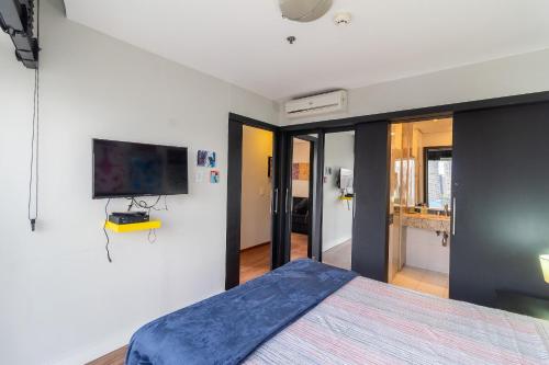 a bedroom with a bed and a tv on a wall at LFlats no Hotel Stella Vega (EX-Mercury Ibirapuera) in Sao Paulo