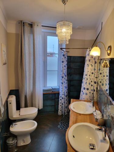 a bathroom with two sinks and a toilet and a window at Moderne, stilvolle Ferienwohnung in Stralsund 84m2 in Stralsund