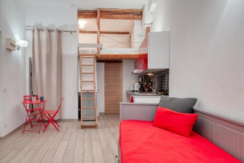 un salon avec un canapé rouge et une cuisine dans l'établissement Très beau studio idéalement situé centre ville, à La Ciotat
