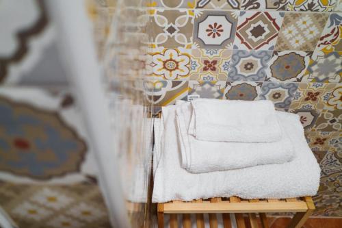 een stapel handdoeken op een tafel in een kamer bij Le Maioliche in Saponara Villafranca