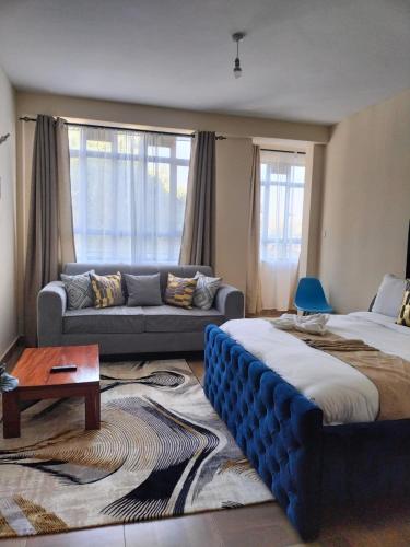 a living room with two beds and a couch at Cosy Studio Apartment in Nakuru.Lift.Wifi.Ample Parking in Nakuru