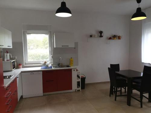 eine Küche mit einem Waschbecken und einem Tisch mit Stühlen in der Unterkunft House Garden House in Kaštela