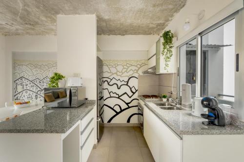 una cocina con encimeras blancas y fregadero en Fliphaus Ravignani 1300 - 1 Bd Pool & Bbq en Buenos Aires