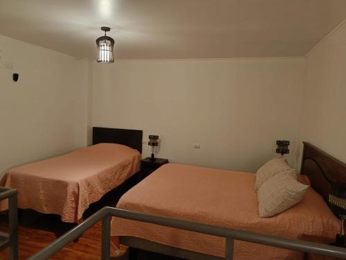 カルデラにあるCafetto Hostalのベッド2台と階段が備わる小さな客室です。