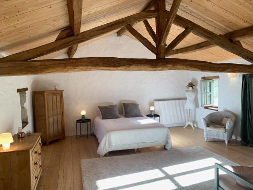 ein Schlafzimmer mit einem Bett und einer Holzdecke in der Unterkunft Maison de charme avec piscine in Orches