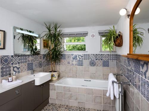 uma casa de banho com uma banheira, um lavatório e 2 janelas em 2 Bed in Brecon Town BN140 em Brecon