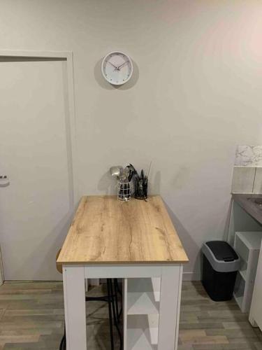 une table en bois dans une cuisine avec une horloge murale dans l'établissement Chez Maryline-joli T2 spacieux, à Villeurbanne
