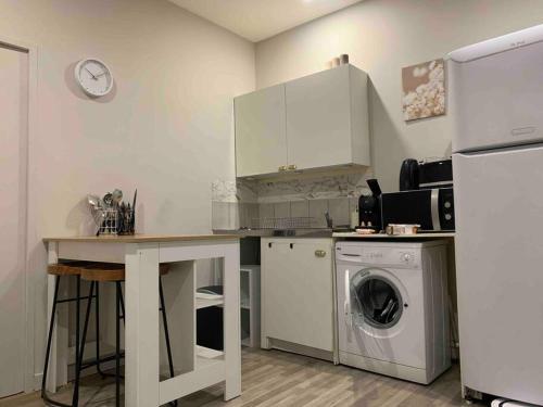 une cuisine avec une table et une machine à laver dans l'établissement Chez Maryline-joli T2 spacieux, à Villeurbanne