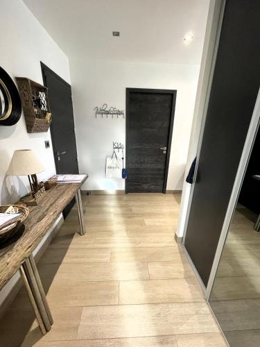 a hallway with a wooden floor and a black door at Maison et piscine chauffée, vue Monts du Lyonnais in Brullioles