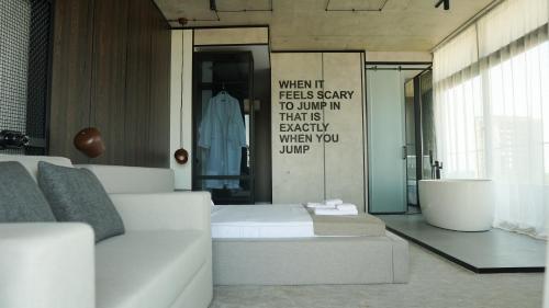 a living room with a couch and a sign on the wall at Hotel Nobilis Hall in K'obulet'i