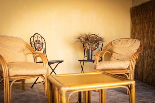 a room with two chairs and a table with a gold table at Sa Domu de Ladiri - matrimoniale con giardino in Musei