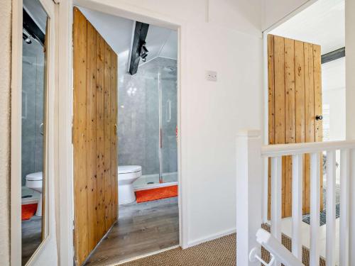 a bathroom with a toilet and a glass door at 3 Bed in Nefyn 55571 in Nefyn