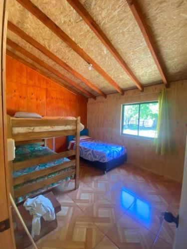 Habitación con 2 literas y ventana en Cabaña las gotas Coñaripe 2, en Coñaripe