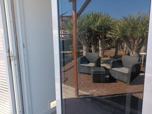 テヒーナにあるCamping Invernaderitoの椅子2脚と椰子の木の窓