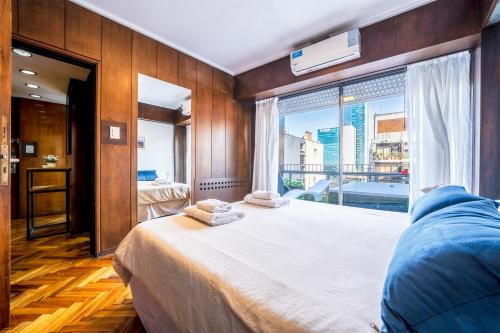 1 dormitorio con cama grande y ventana grande en Fliphaus Santa Fe 800 - 1 Bd Terrace Pool Bbq en Buenos Aires