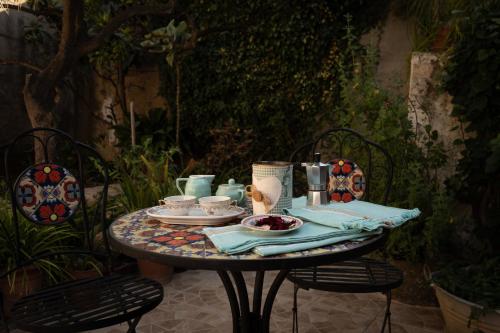 una mesa con platos y tazones de comida. en Sa Domu de Ladiri - GuestHouse con bagno privato e giardino, en Musei