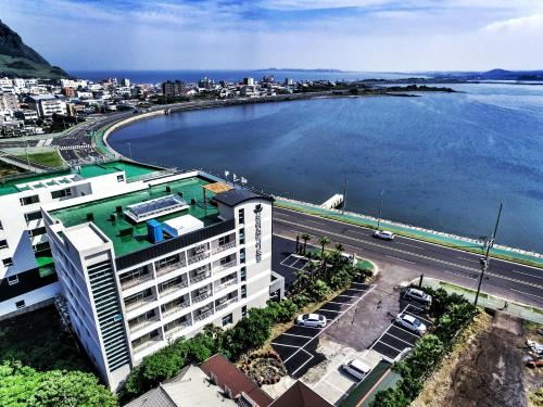 an aerial view of a building next to a body of water at Breeze Bay Hotel in Seogwipo